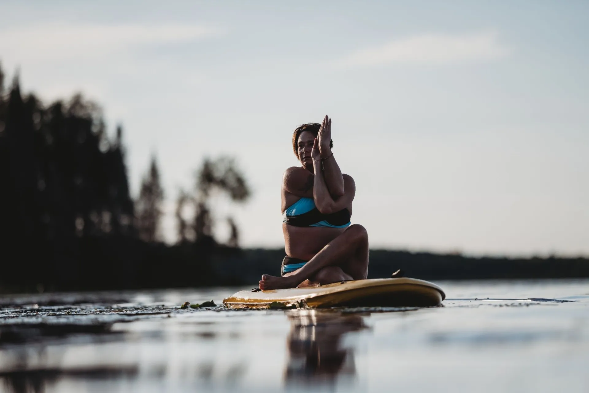 Shelley practising yoga on the water at sunrise